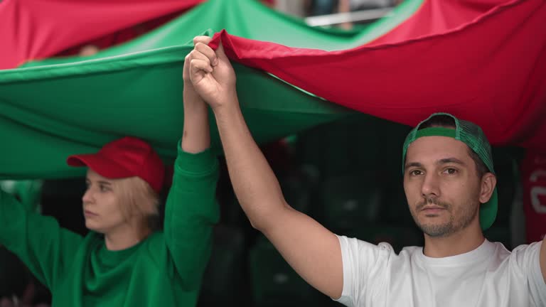 Fans holding freedom honor flag. Patriotic people stand at sport soccer stadium.