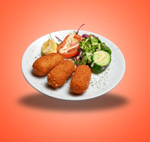 istock Floating White plate with three Shrimps croquettes ans salad 1474791392