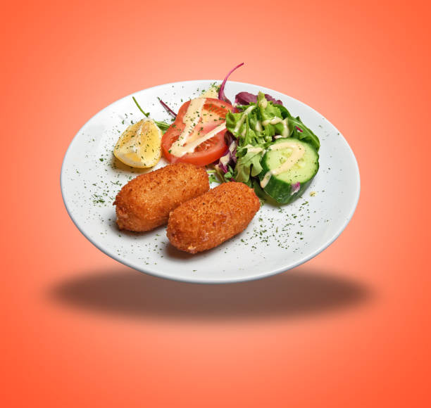 istock Floating White plate with two Shrimps croquettes ans salad 1474791472