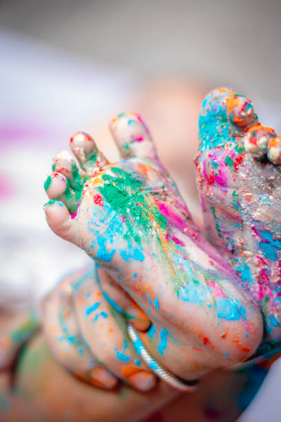 istock infant little colorful feet at holi from unique angle 1474794208