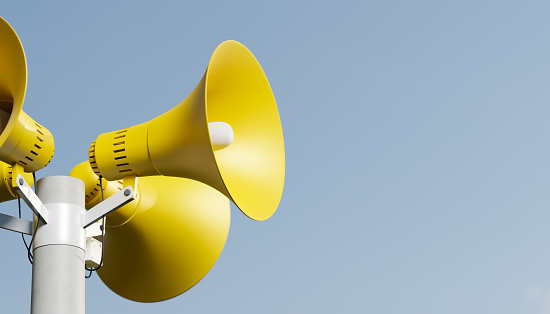 Notificación de megafonía altavoces en una publicación, renderizado 3D. Megáfonos de notificación al aire libre para anuncio o alerta de ataque aéreo, fondo amarillo y azul photo