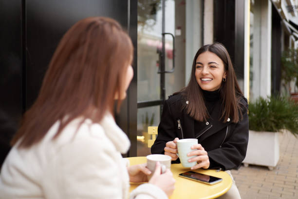 istock Female friends smiling while enjoying having a coffee together in a cafe. 1474796298