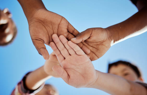 istock Diversity, stack of hands and children in unity, support or solidarity with a blue sky background. Solidarity, collaboration and multiracial kid friends cheering together for motivation, fun and joy. 1474797543