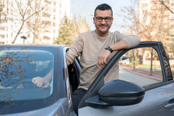 man leaning on car door - car car door car key door imagens e fotografias de stock