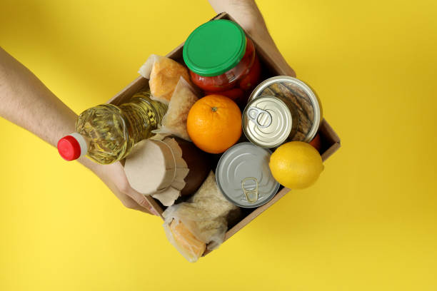 istock Male hands hold donation box on yellow background 1474797642