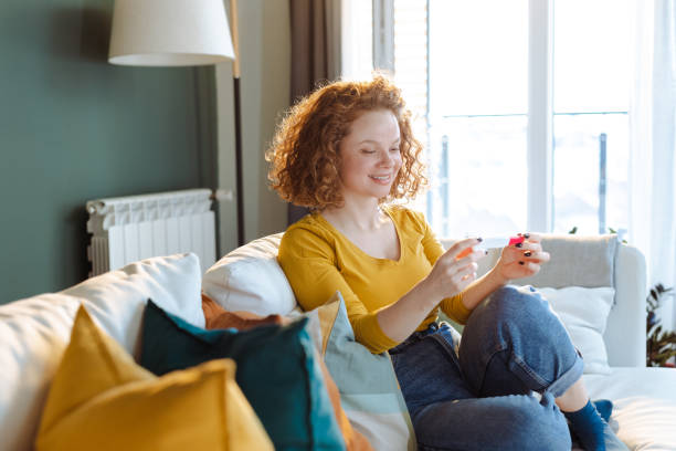 istock Happy woman holding pregnancy test 1474797764