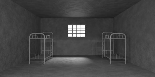 istock Prison cell with bunk beds and metal bars on window 3d render. Realistic interior of empty dark jail room with grey walls and sunlight on floor. Cage for criminals with furniture 1474799321
