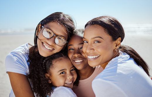 Black family, summer and kids portrait at ocean with lesbian parents enjoying USA summer vacation in sun. Love, care and happy family hug together with smile on holiday break at beach.