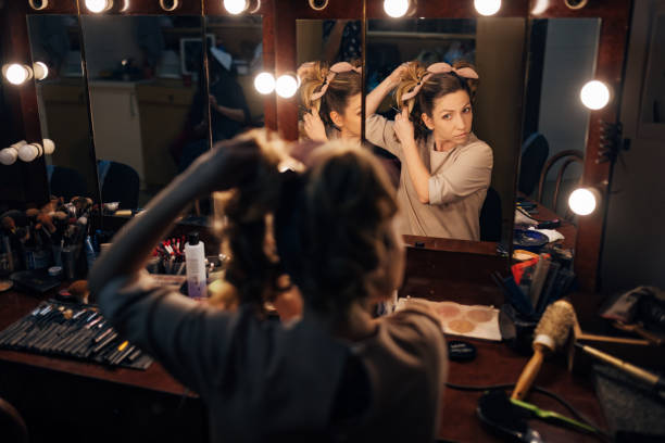 istock While sitting in front of the mirror in the theater backstage, the professional actress fixes her hair 1474800359