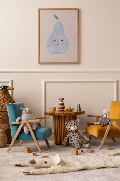 Interior design of kids room with mock up poster frame, round wooden table, blue, orange armchair, plush toys, animal rug, wooden blockers, wicker basket and personal accessories. Home decor. Template diseño interior de la habitación de los niños con marco de póster de maqueta, mesa redonda de madera, sillón azul, naranja, juguetes de peluche, alfombra de animales, bloqueadores de madera, cesta de mimbre y accesorios personales. decoración del hog