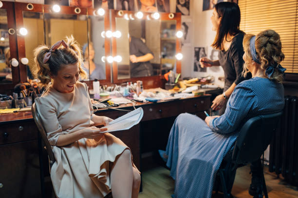 istock A make-up artist applies make-up to a senior actress, while another smiling actress sits next to them and reads the script 1474800914