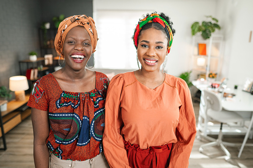 Portrait of two smiling black woman standing in the apartment
