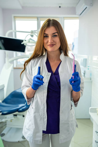 현대 치과 진료소의 제복을 입은 젊은 예쁜 여성 치과 의사의 초상화 - dentist dental hygiene dental assistant dentist office 뉴스 사진 이미지