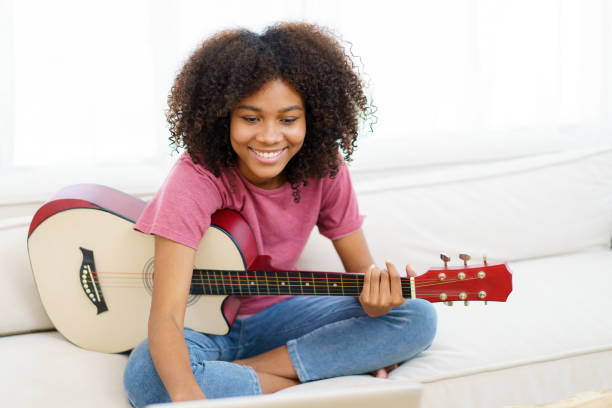 istock Happy black woman playing guitar. 1474806943
