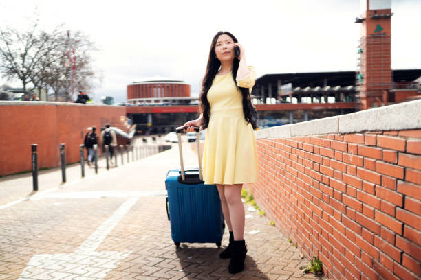 A girl with a suitcase arriving at the station looking for a tourist flat. stock photo