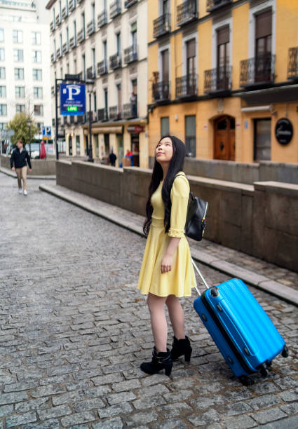 A tourist girl walking around with her suitcase looking for tourist flats stock photo