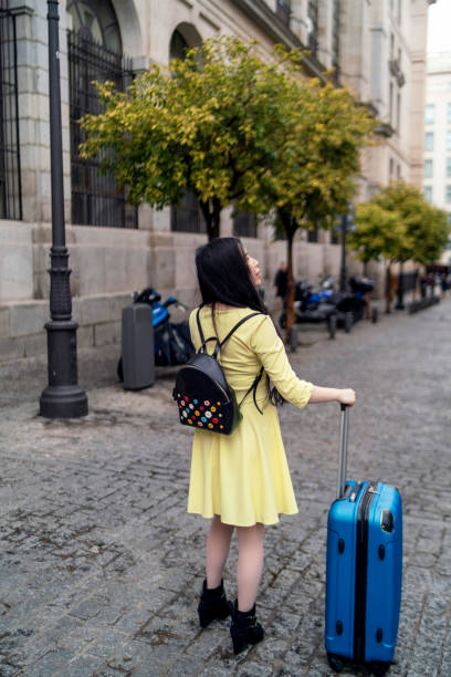 A tourist girl walking around with her suitcase looking for tourist flats stock photo