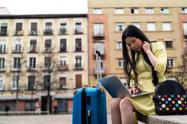 A tourist girl sitting with her laptop looking for tourist flat. stock photo