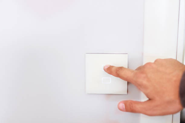 istock Closeup of man's finger turning off on lighting switch to save 1474810072