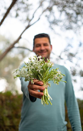 Young Man is Holding a Bouquet of Flowers