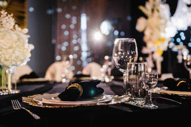 istock Serving, setting table. Plate decorated linen black napkin and silverware cutlery, glasses. Side view. Closeup. Wedding set up, dinner table reception. Birthday, baptism, event. Luxury golden decor. 1474811992