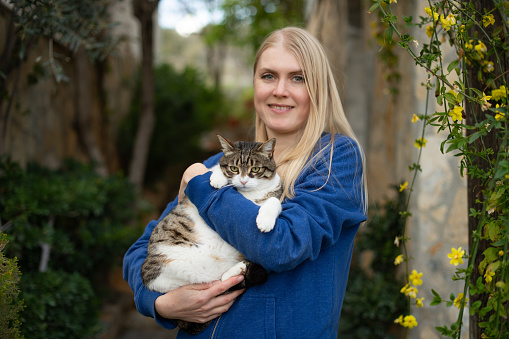 Woman Posing With Her Cat in Her Arms