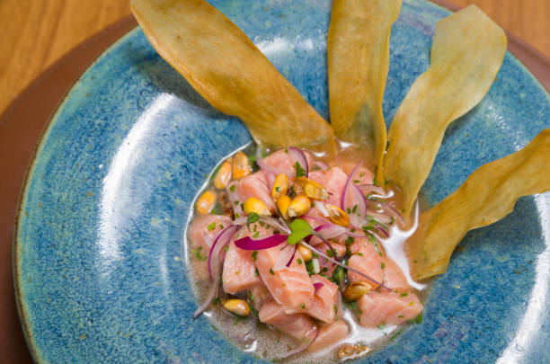 delicioso ceviche de salmón con verduras, especias y limón de cerca en un plato en la mesa. vista superior horizontal desde arriba - seviche prepared ahi freshness mexican culture fotografías e imágenes de stock