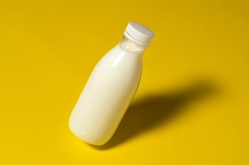 Bottle of a milk isolated on yellow bakcground