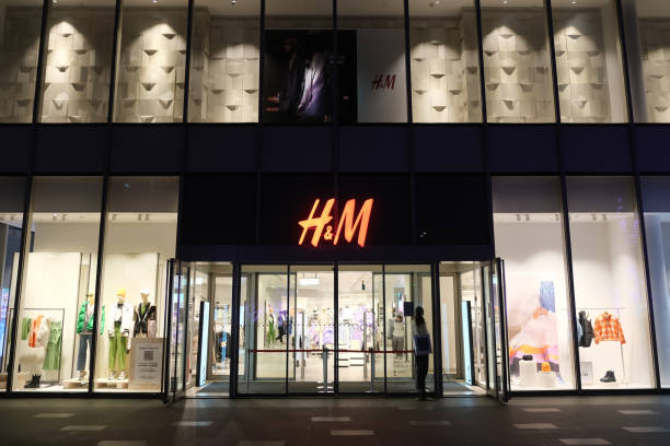 facade of large H&M clothing store Shanghai,China-Nov.26th 2022: facade of large H&M clothing store at night h and m stock pictures, royalty-free photos & images