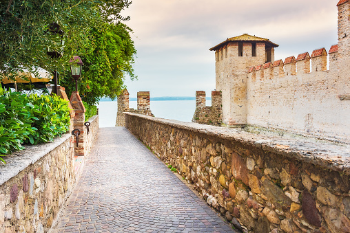 Sirmione castle on Garda lake. A narrow alley leading to the lakefront promenade, Italy, Lombardy region, on the shores of Lake Garda.