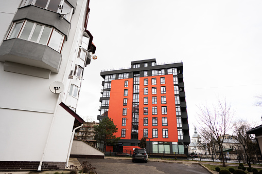Ivano-Frankivsk, Ukraine - March, 2023: Modern and new orange multistoried apartment building in one of street Ivano Frankivsk.