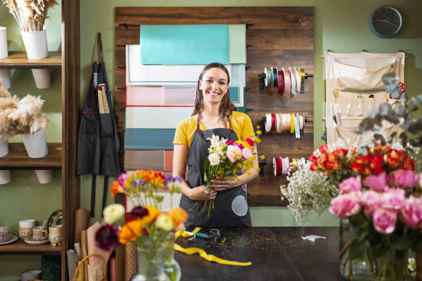 istock Cheerful young florist making bouquet looking at camera 1474821323