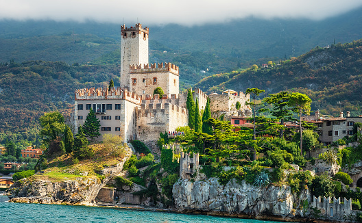 Old castle on the rock. Town of Malcesine at Garda lake. Summer landscape with  green trees. Veneto region, Italy.