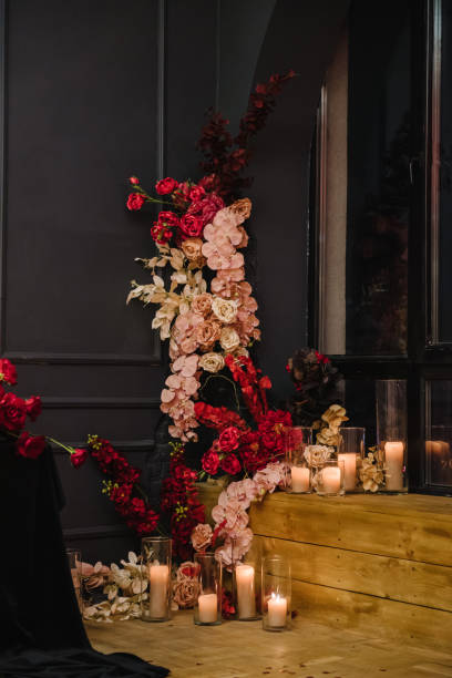 istock Luxury candlelight dinner setup for couple on Valentine's day. Romantic date. Setting table in restaurant. Location decoration red flowers, decor candles for surprise marriage proposal. Closeup detail 1474825071