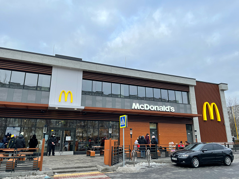 Halifax, Nova Scotia, Canada - October 13, 2011: Exterior of newly re-designed McDonalds location with a car waiting in the Drive Through lane on Lacewood Drive in Halifax. McDonalds has recently begun renovating many of their locations to a new, more modern look featuring the McCafe branding.