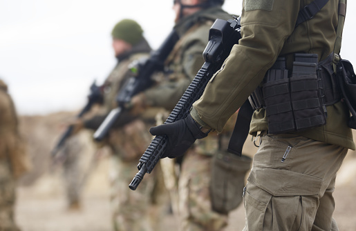 Grupo de soldados ucranianos equipados con modernos rifles de asalto entrenando en el campo de tiro. Militares armados con ametralladoras automáticas practicando al aire libre photo
