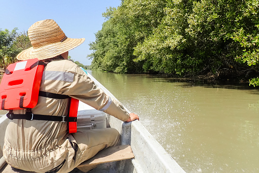 A biologist traveling on a boat on the river