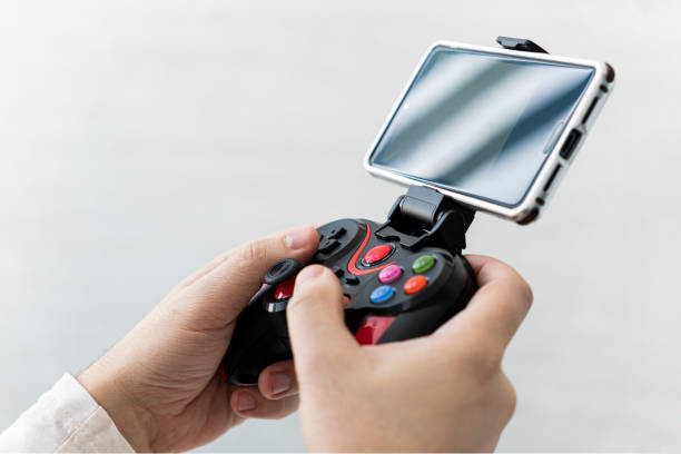 istock Man playing on smartphone. joystick connected to a smartphone wirelessly. The game is on the phone. 1474829484