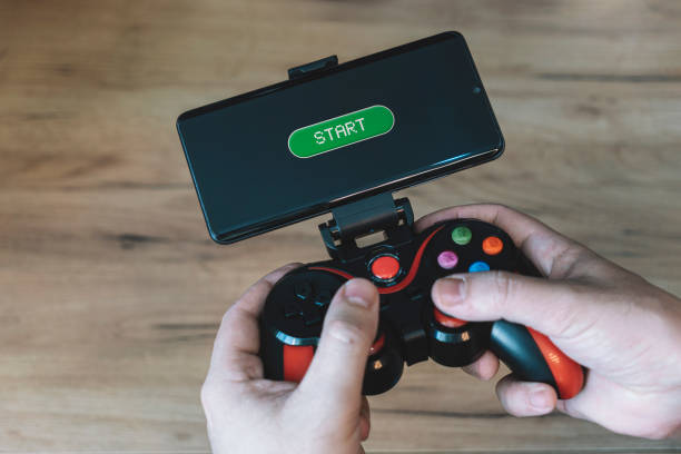 istock a gamer plays on a smartphone. Hands with joystick with phone 1474829485
