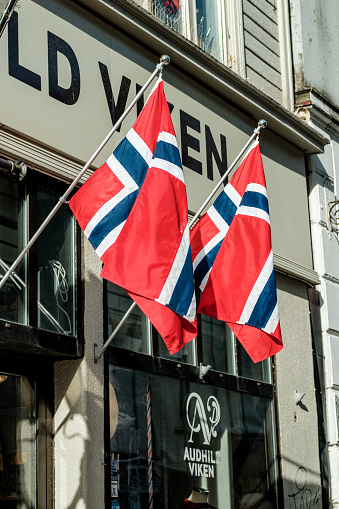 Stavanger, Norway, March 10 2023, Two Norwegian National Flags Hanging On Poles Outside A Building With No People
