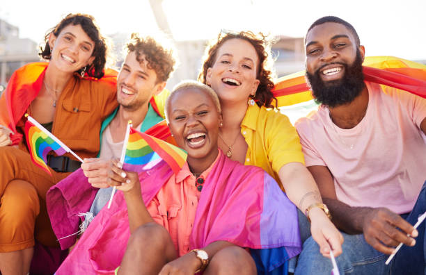 Portrait, diversity and rainbow flag for lgbtq community, freedom and smile for parade, support or solidarity. Friends, group or young people with non-binary, gay and lesbian with happiness and queer stock photo
