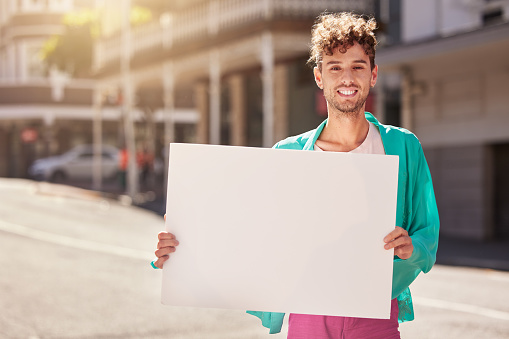 Mockup, portrait and man with board, street and protest for human rights, social change and equality. Young person, male and protester with blank card, marching and in city with smile and activist