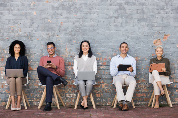 istock Diversity, Interview and relax business people line with technology for meeting, recruitment or company hiring. Human resources, employees happy and working on laptop, tablet or smartphone in studio 1474830843