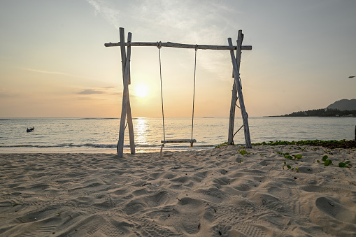 Swing on the beach at sunset