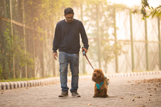 istock Young Man walking With his Pet Dog At Park 1474832776