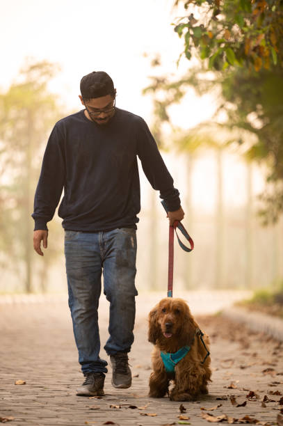 Young Man walking With his Pet Dog At Park