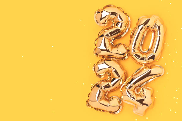 istock 2024 gold colored inflatable balloons on a yellow background with place for text. 1474833271