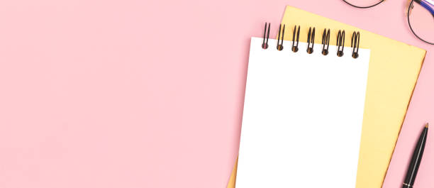istock Banner with blank notepad mockup and stationery on a pink background. 1474834528