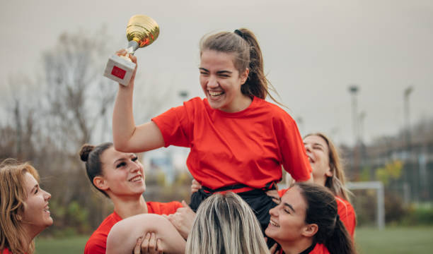 istock Female rugby team celebrating a trophy 1474834907