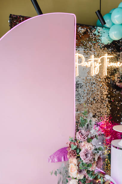 istock Luxury arch is decorated with flowers. Silver wall with text party time. Light blurred background for birthday. Photo zone with black lights, silver, pink, blue balloons, disco style, led strip. 1474834936